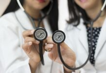 জার্মানিতে অসুস্থ হলে কী করবেন? ‘হাউস আর্টজ’ (Hausarzt) এবং অ্যাপয়েন্টমেন্ট গাইড Sign on a German medical practice door reading "Hausarzt" (General Practitioner) with a stethoscope.